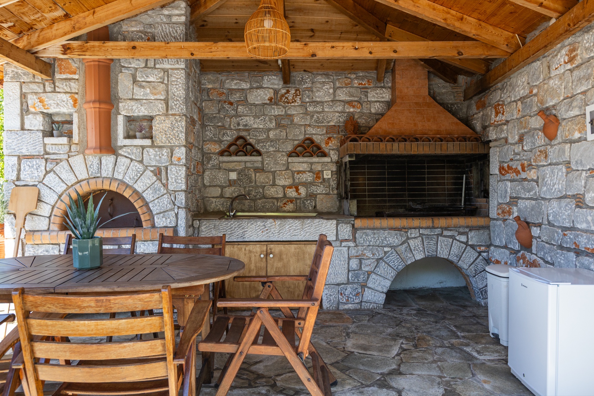 Outdoor BBQ area in stone courtyard, Koufantonis Mansion Mani