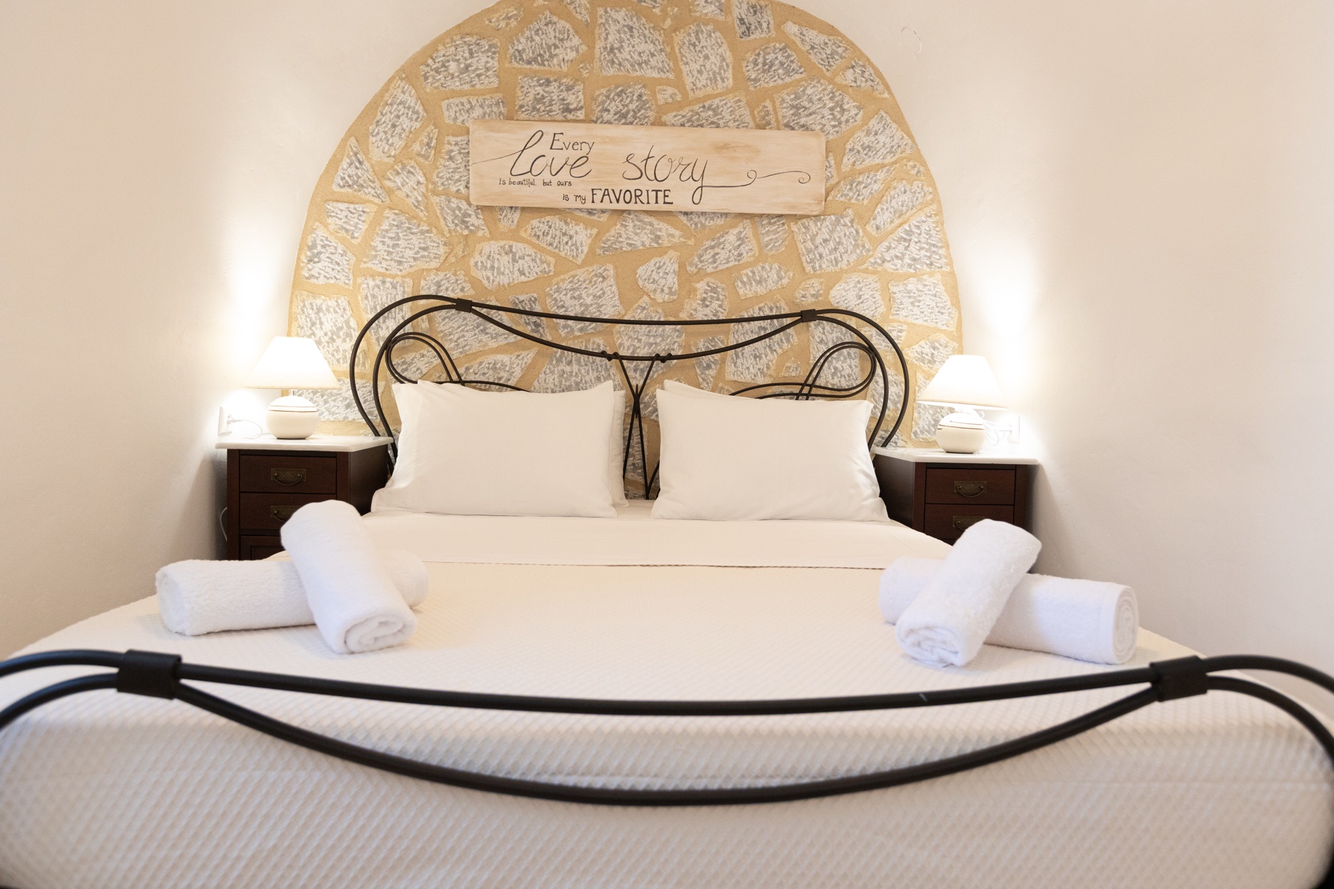 Double bed with handcrafted headboard under stone arch, Koufantonis Mansion