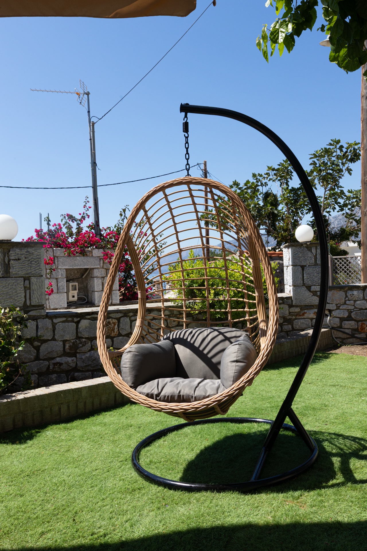 Hanging egg chair in garden with sea view, relaxing vacation rental Mani Greece