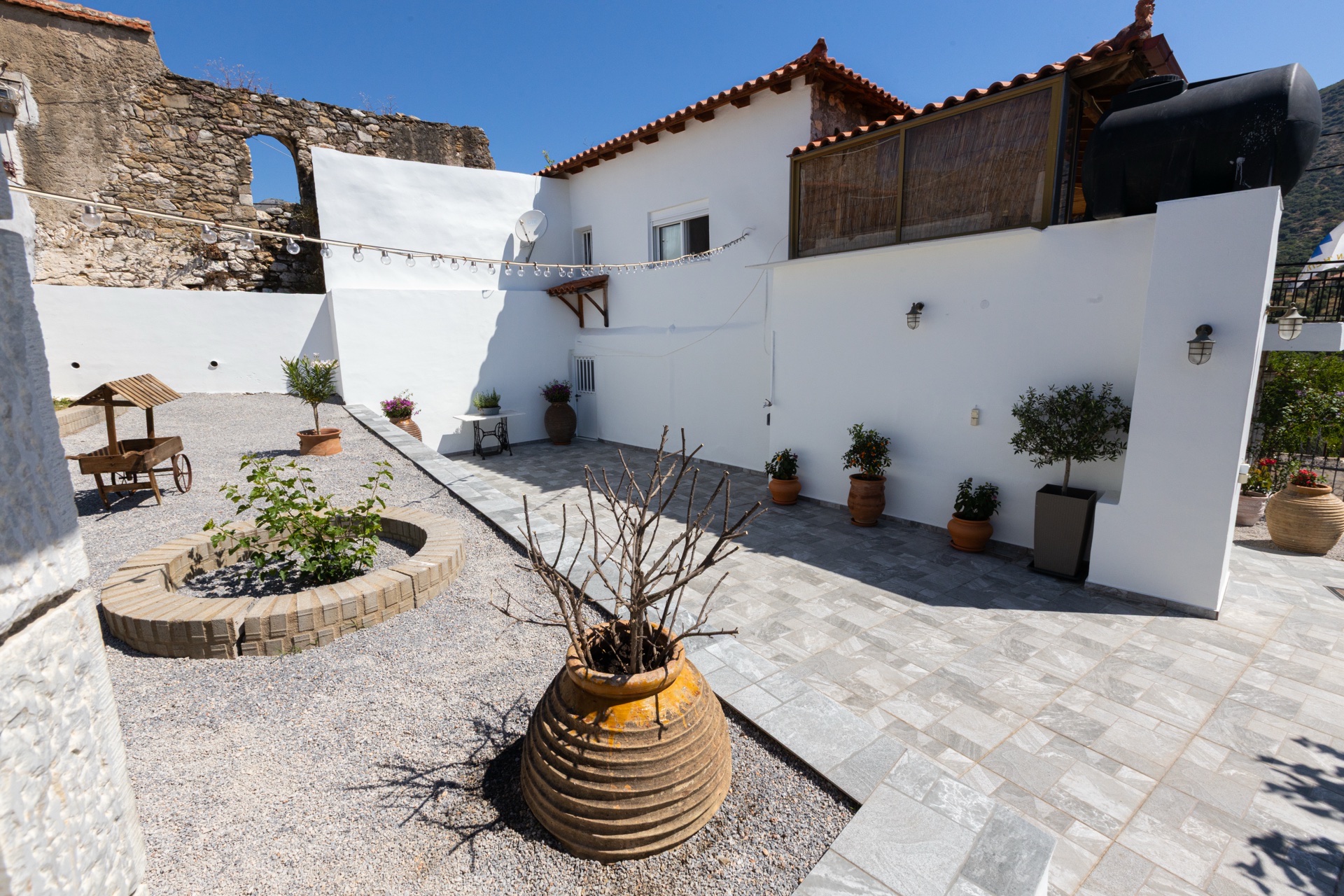 Stone courtyard with Mani tower and garden, Koufantonis Mansion Greece